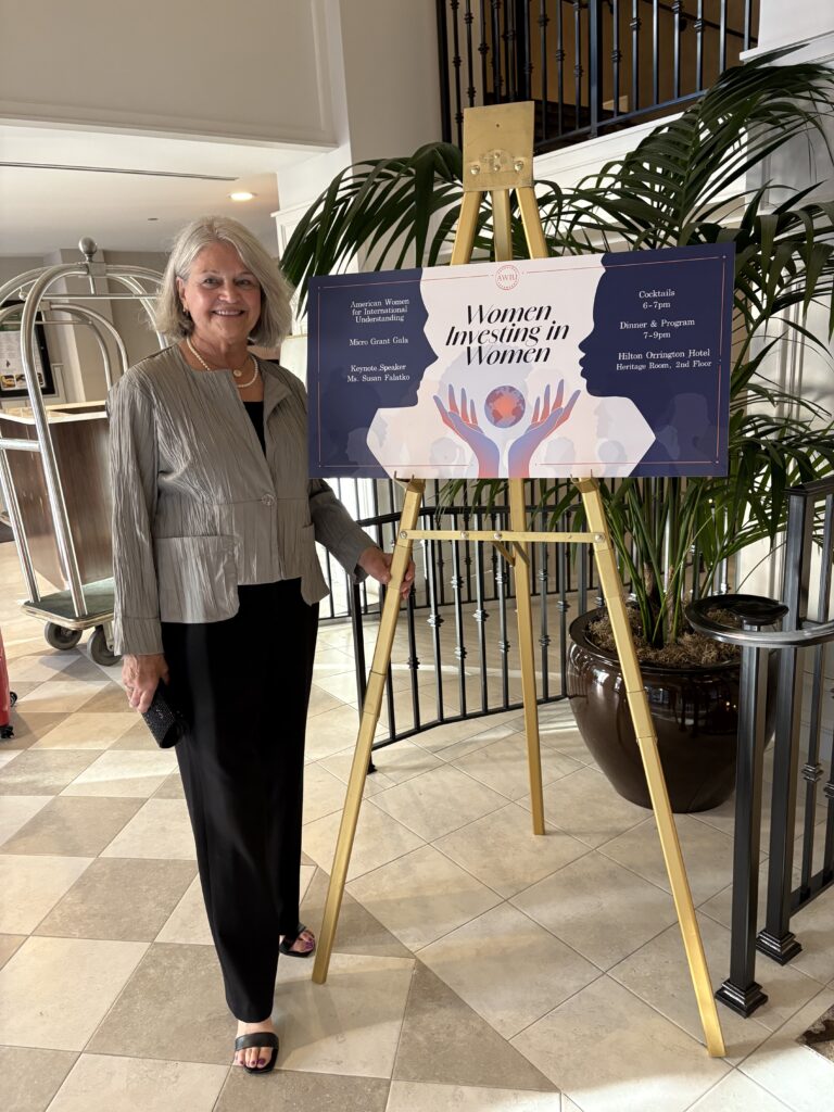 Photo of Mary Pat Garr in front of Women Investing in Women event sign