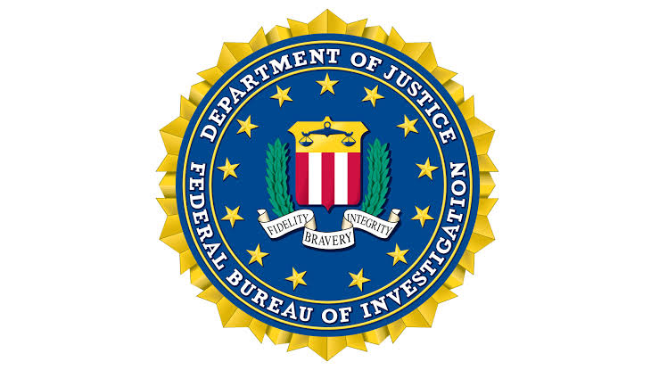 Seal of the Federal Bureau of Investigation, featuring a blue circle with gold text reading "Department of Justice, Federal Bureau of Investigation" and a red, white, and blue shield in the center surrounded by laurel leaves.