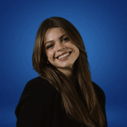Photo of Isabella Berkeley, smiling with long brown hair wearing a black blazer